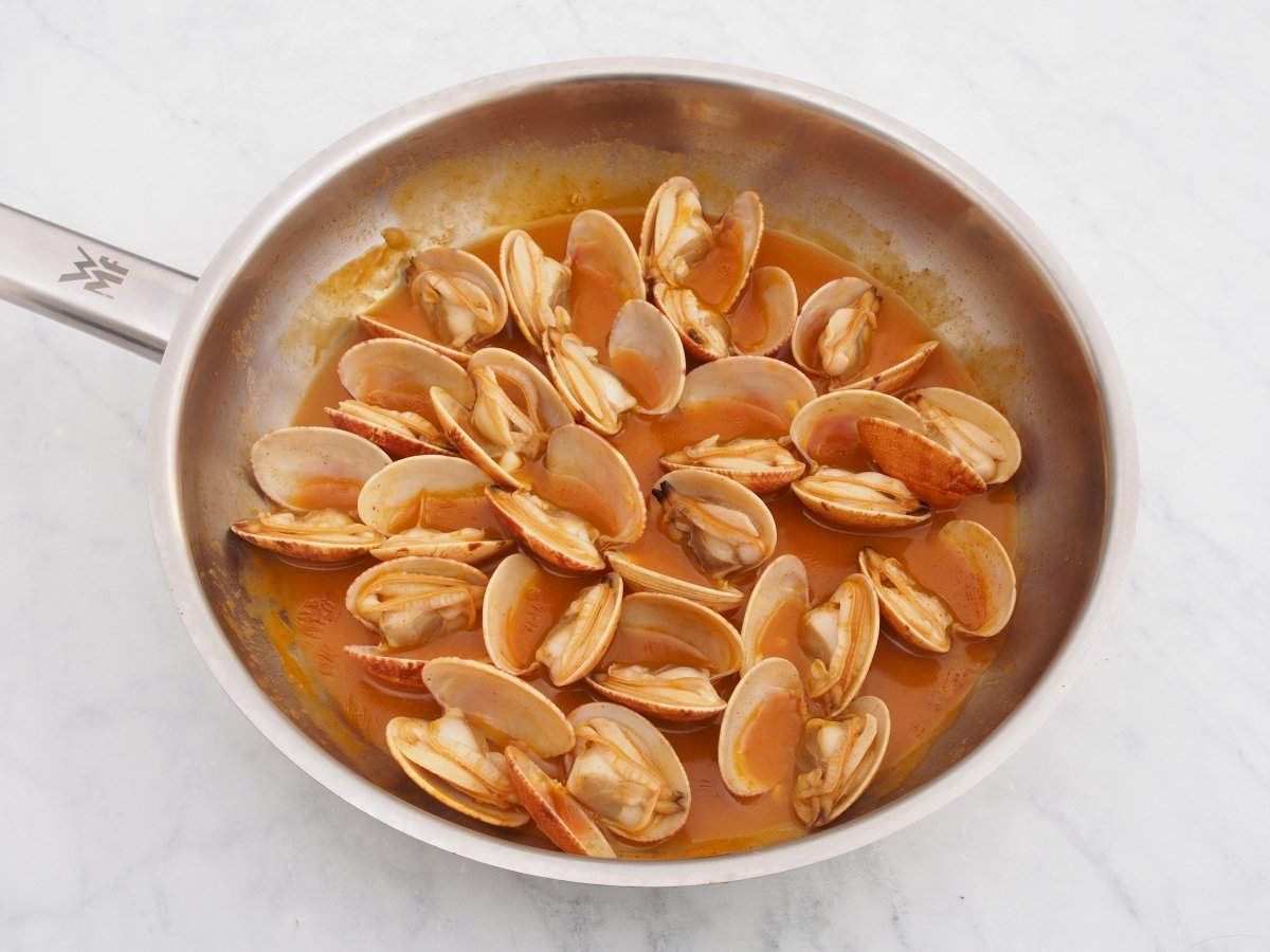 Abrir las almejas en el sofrito para los garbanzos con almejas