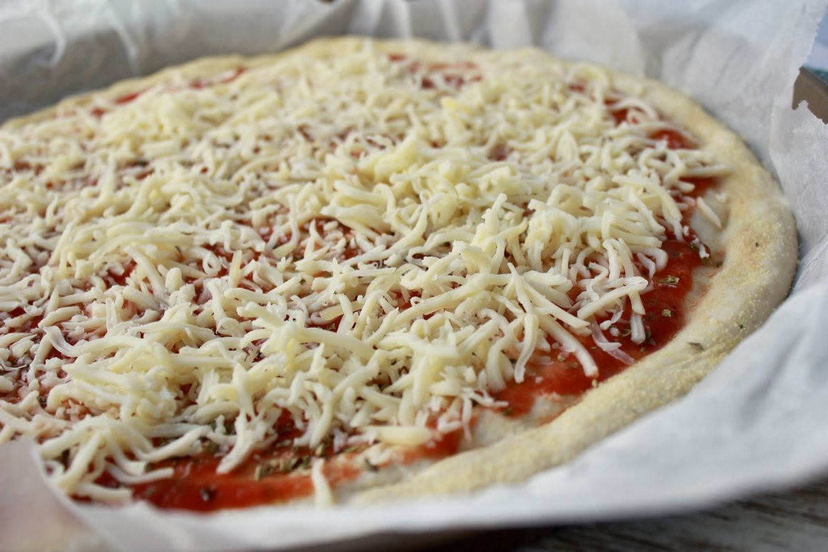 Adición de la mozzarella a la base de pizza casera