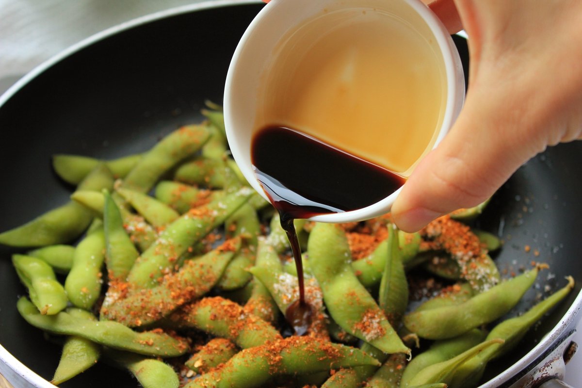 Add the soy sauce to the pan with the edamame