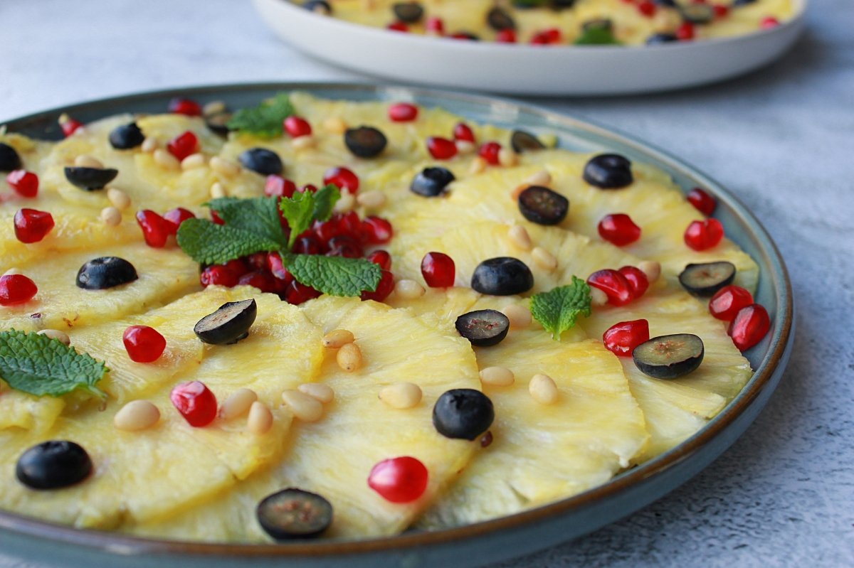 Adding the other ingredients to the pineapple carpaccio