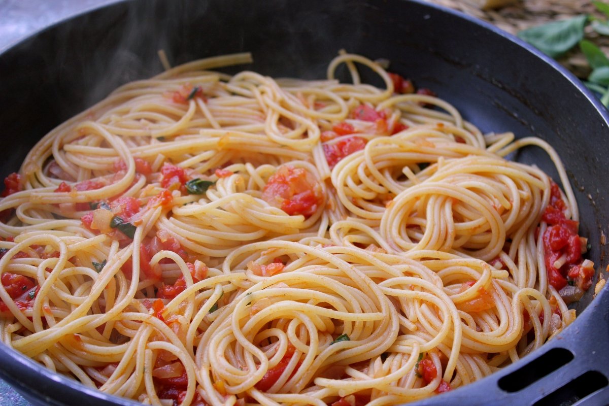 Adición de los espaguetis una vez cocidos a la salsa