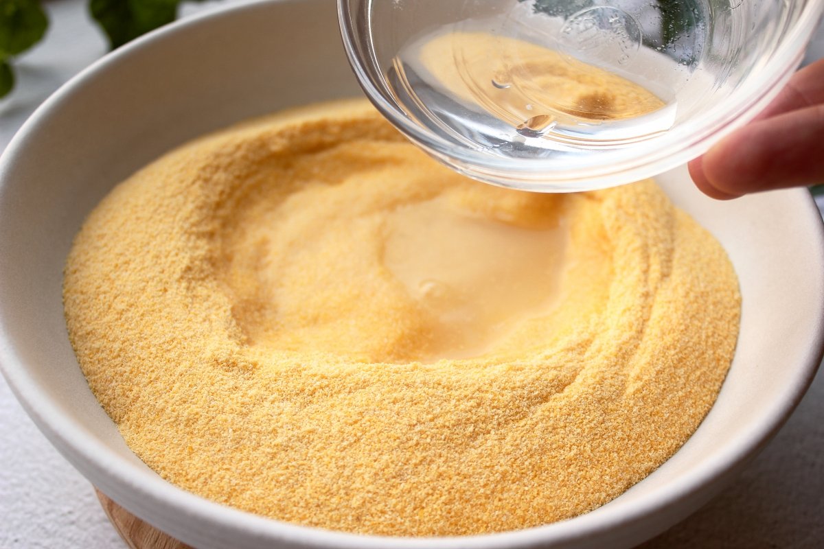 Adding the water with salt in the precooked yellow cornmeal