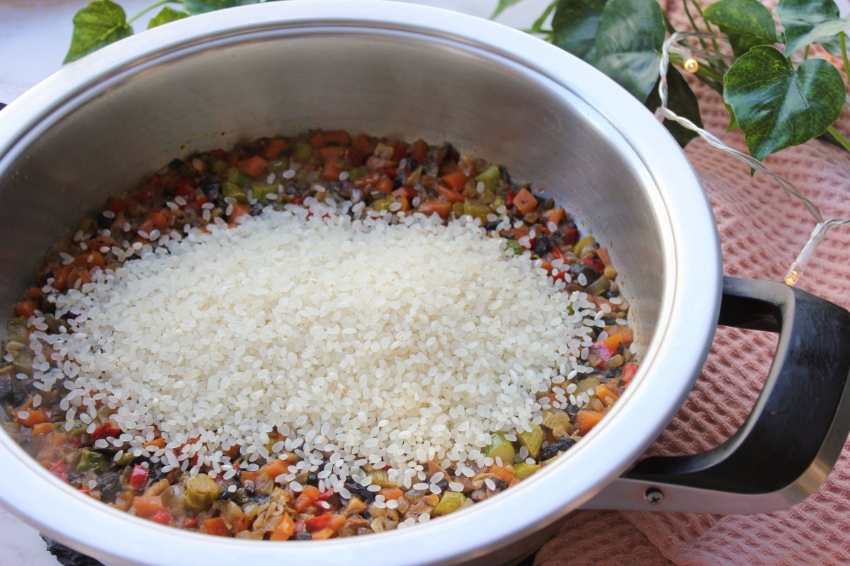 Adición del arroz arborio a la cazuela con los demás ingredientes
