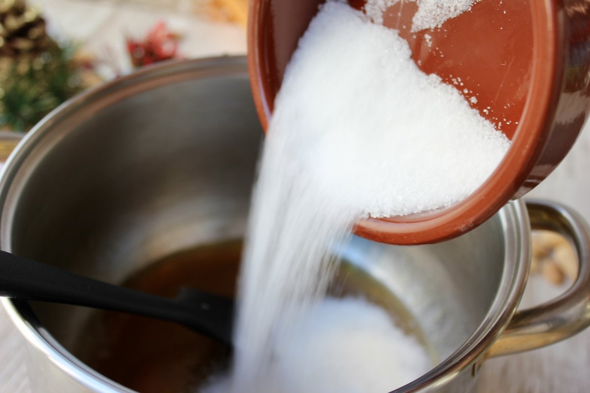 Adición del azúcar al cazo con la miel derretida