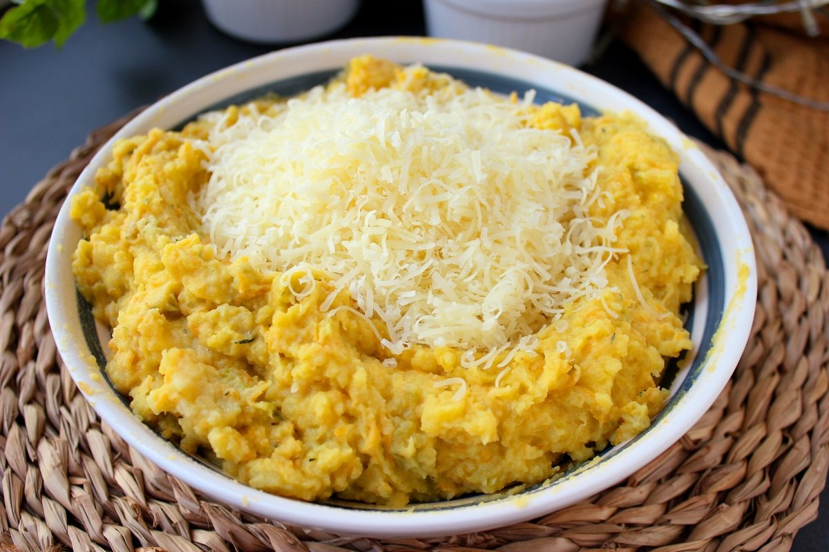 Adición del queso parmesano rallado a la mezcla del puré de patatas