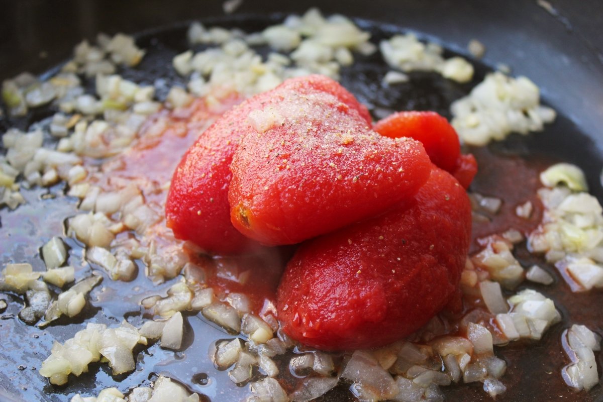Adición del tomate al sofrito de cebolla y ajo