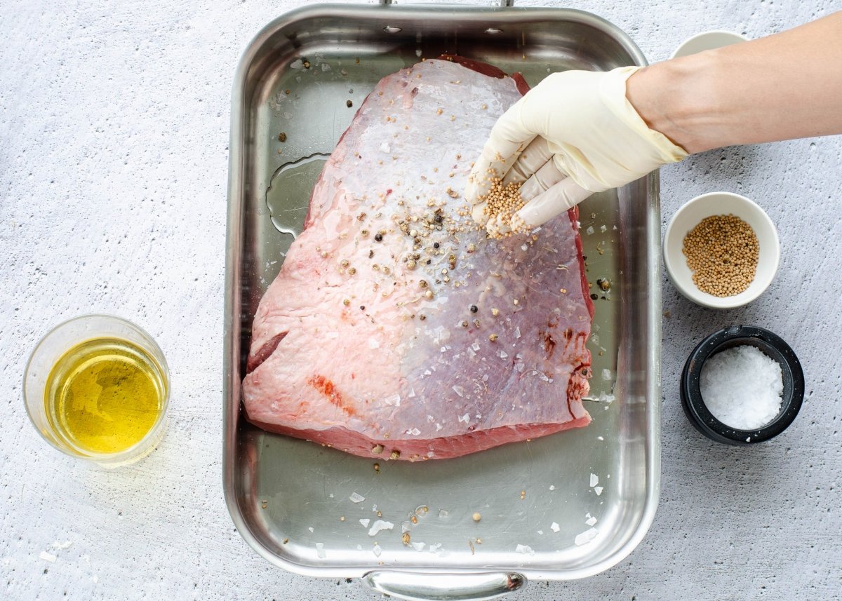 Adobando la carne para hacer picaña de ternera al horno