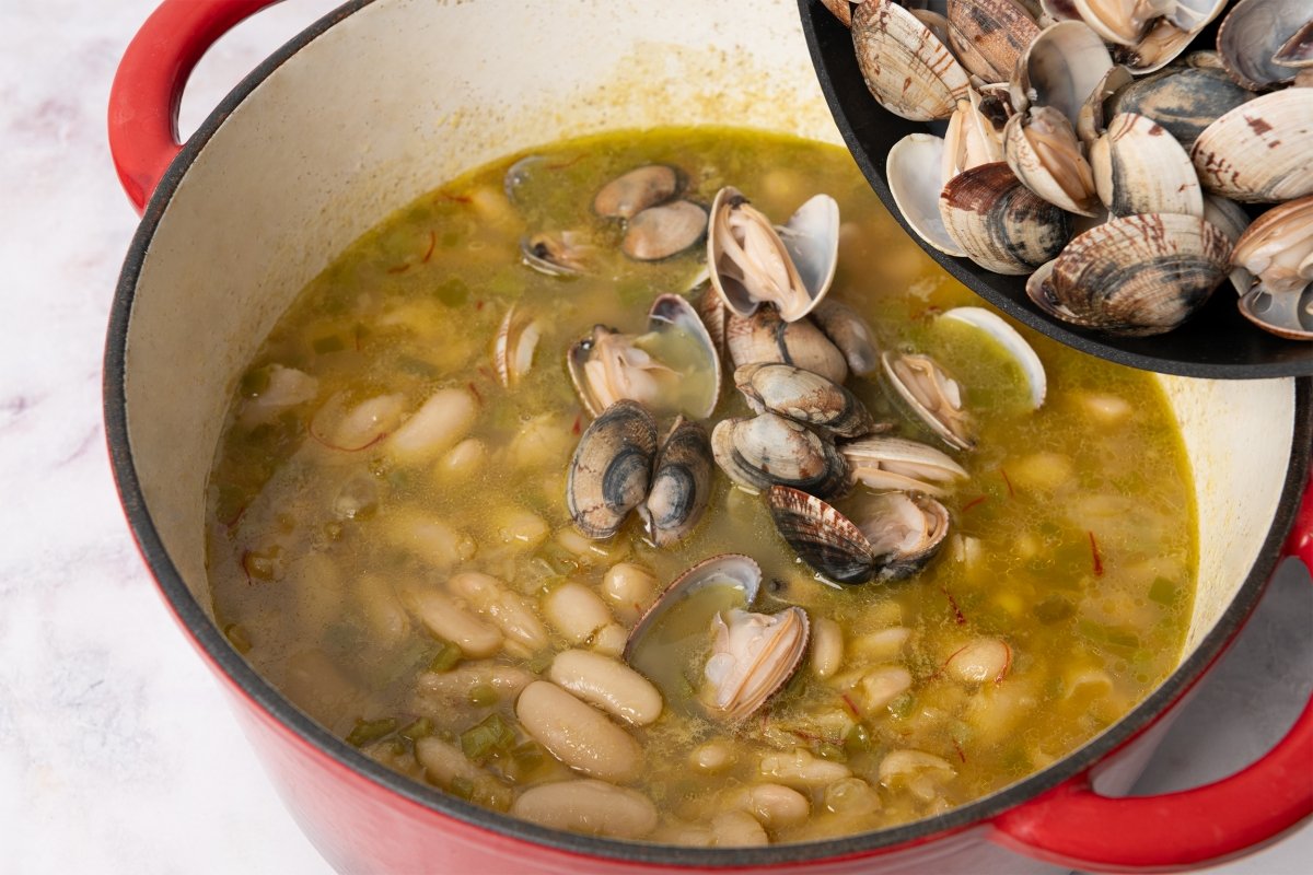 Agregando las almejas a la olla de alubias con almejas