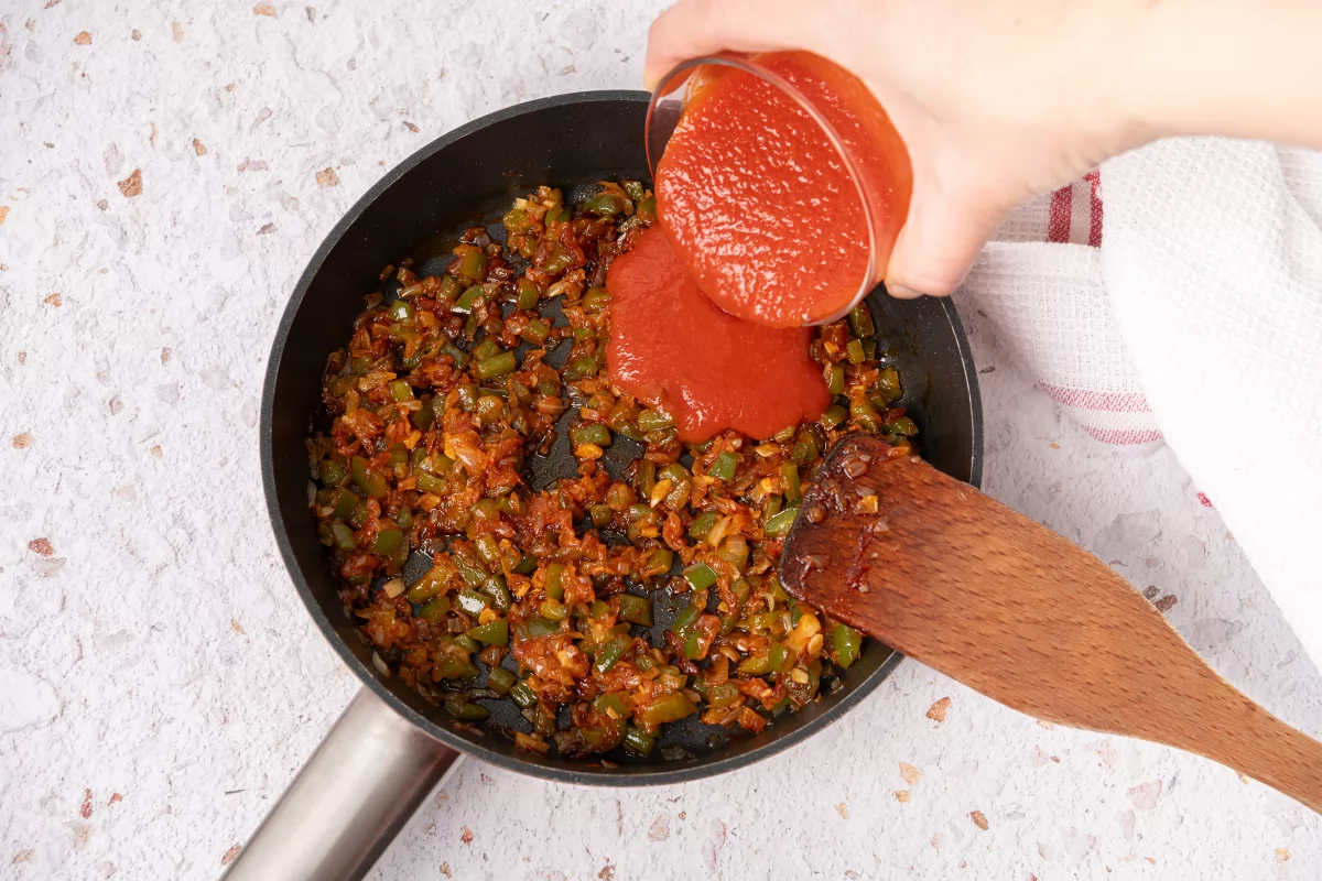 Agregando tomate al sofrito de las judías pintas con arroz