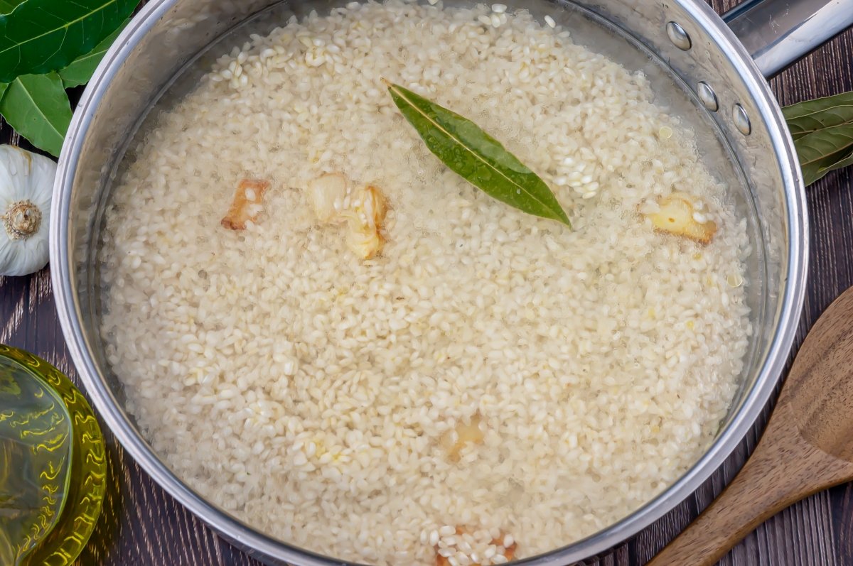 Agregar el agua y el laurel al arroz blanco