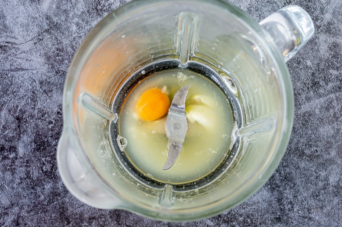 Agregar el huevo, ajo y caldo de pescado de la salsa acevichada