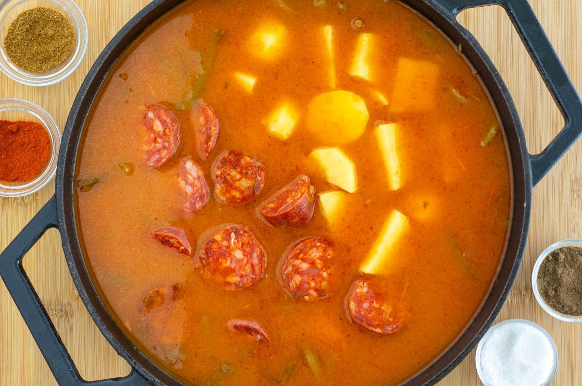 Agregar la patata y el chorizo a los garbanzos con tagarninas