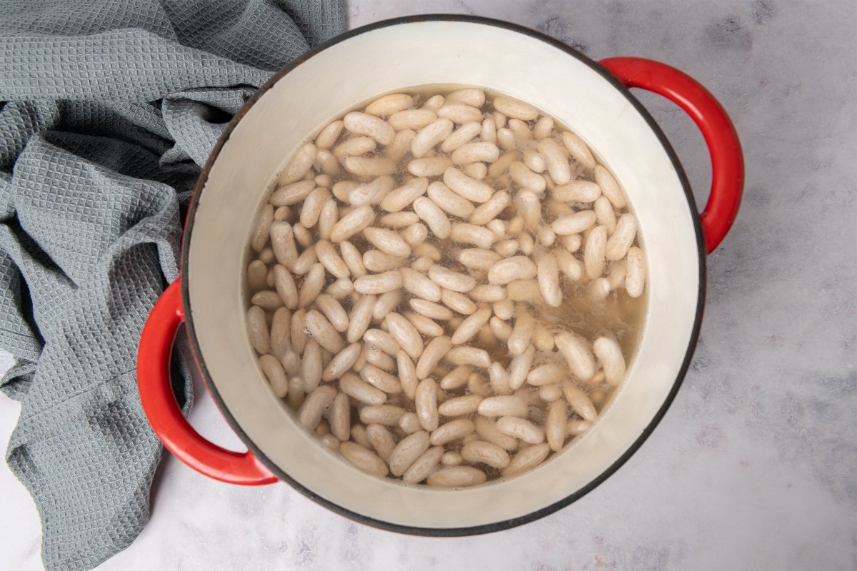 Alubias cocinándose con caldo de pescado para hacer alubias con almejas