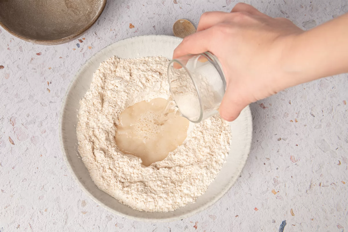 Añadiendo agua a la harina para hacer pan chapati