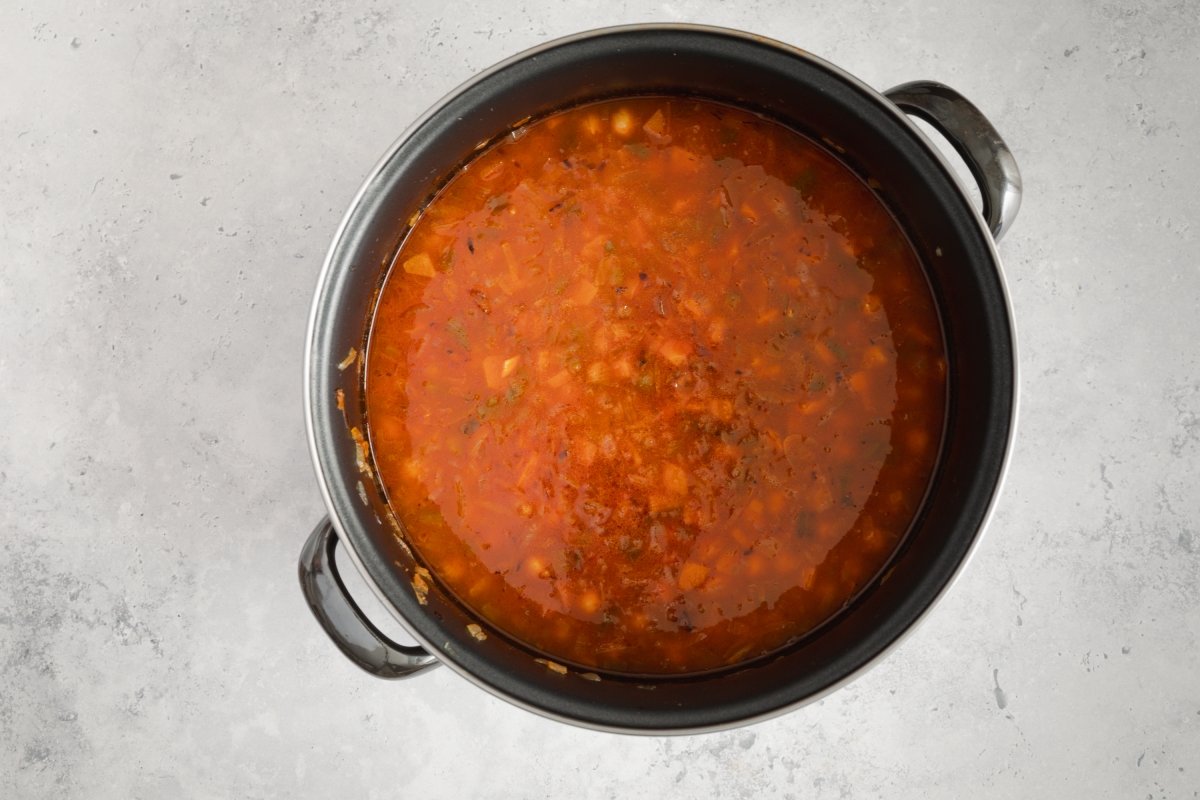 Añadiendo caldo y garbanzos a los garbanzos con arroz