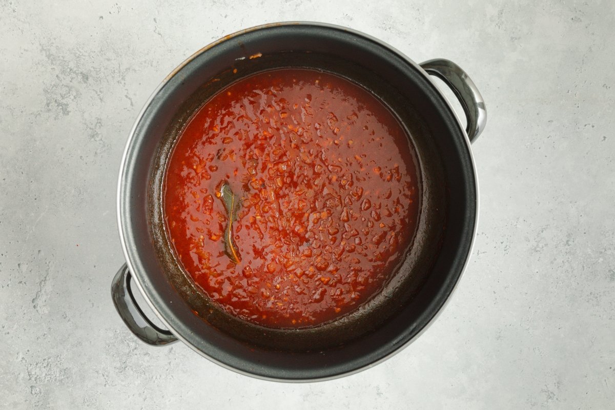 Añadiendo caldo y vino a la merluza a la vizcaína