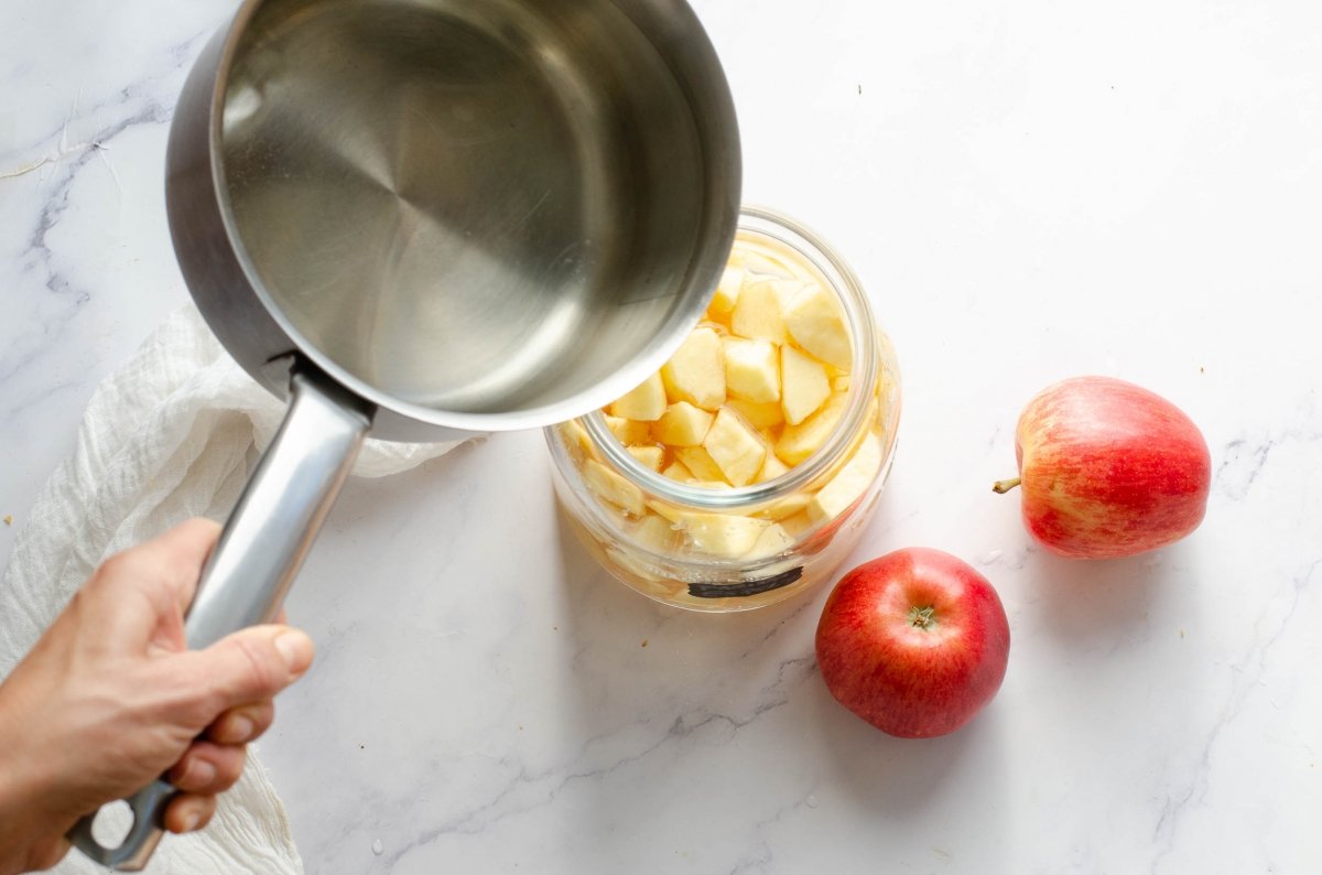 Añadiendo el almíbar para hacer vinagre de manzana