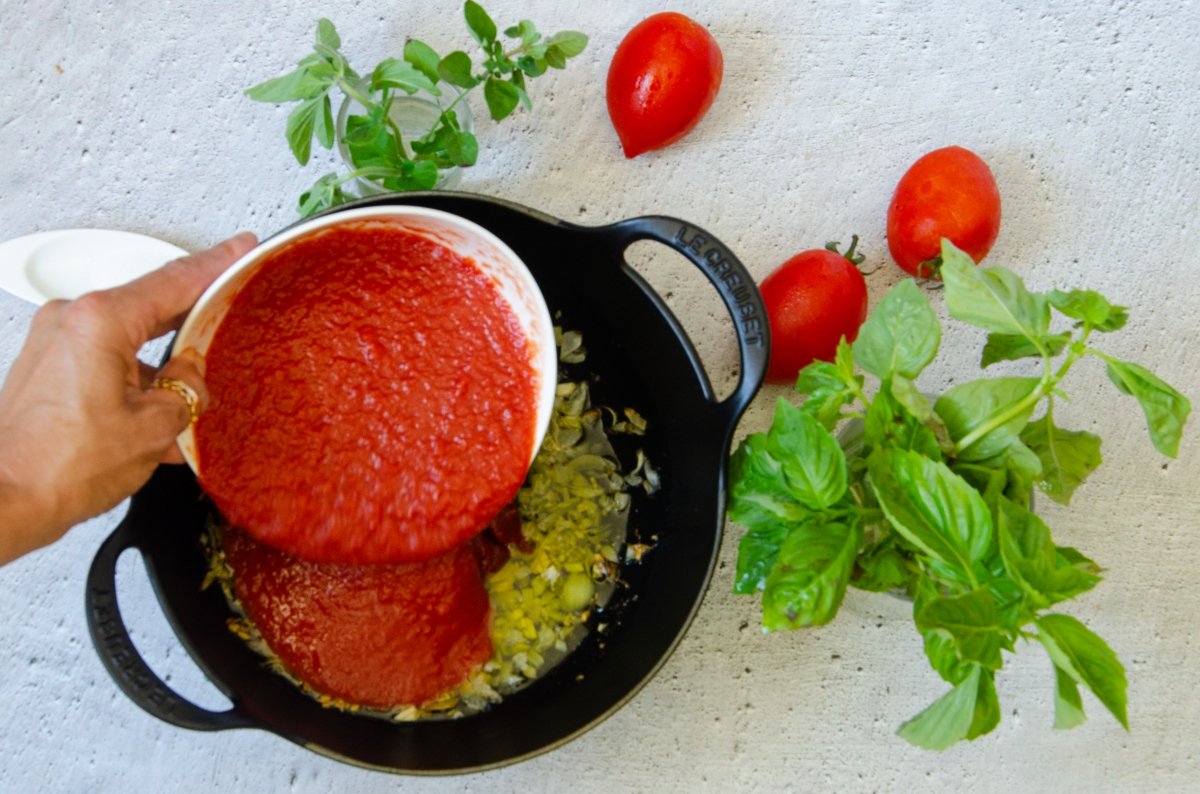 Añadiendo el concentrado de tomate a la cebolla pochada
