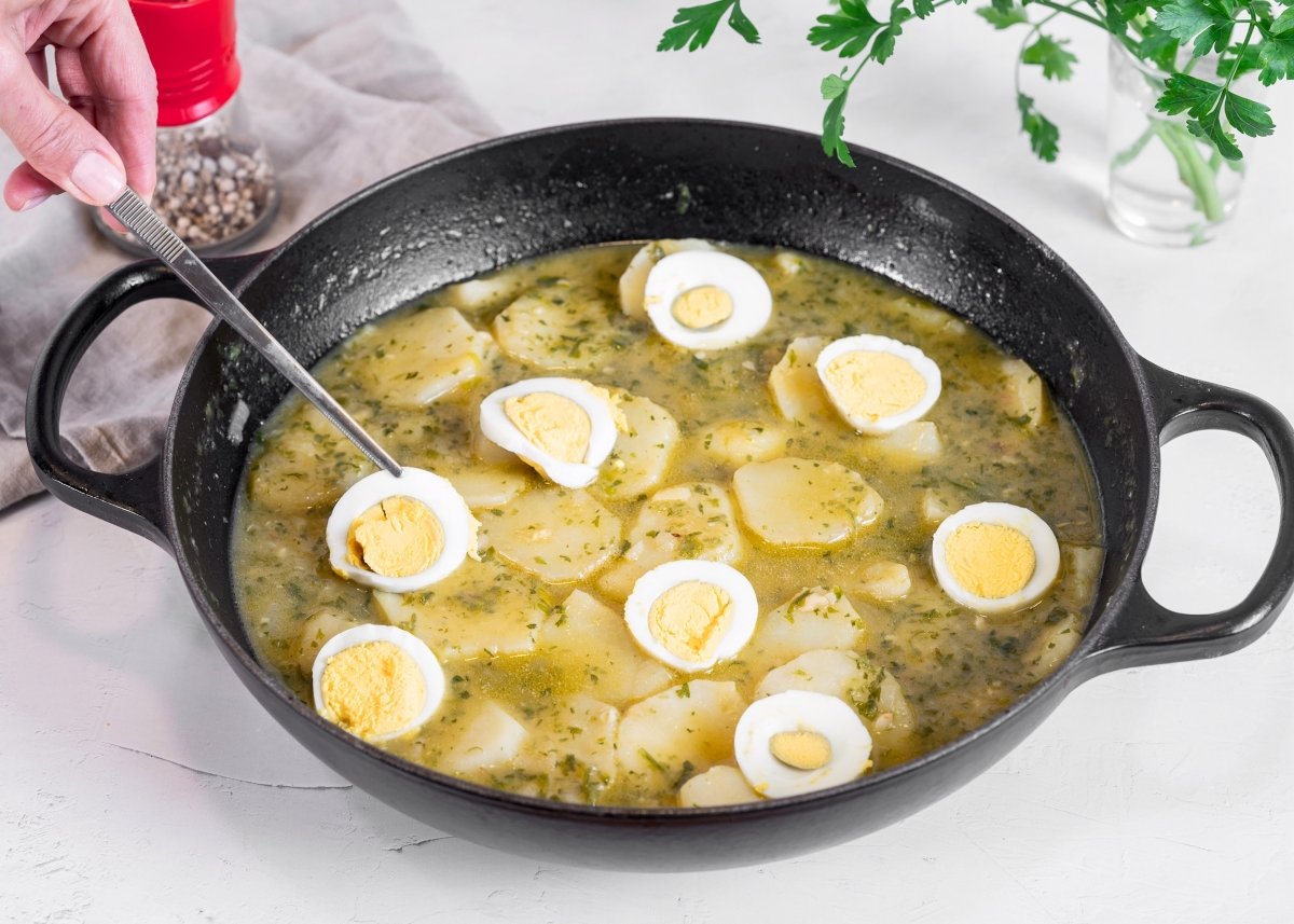 Añadiendo los huevos a las patatas en salsa verde