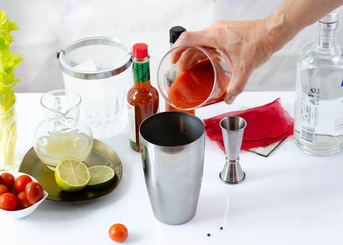 Adding the ingredients to the cocktail shaker to make a Bloody Mary