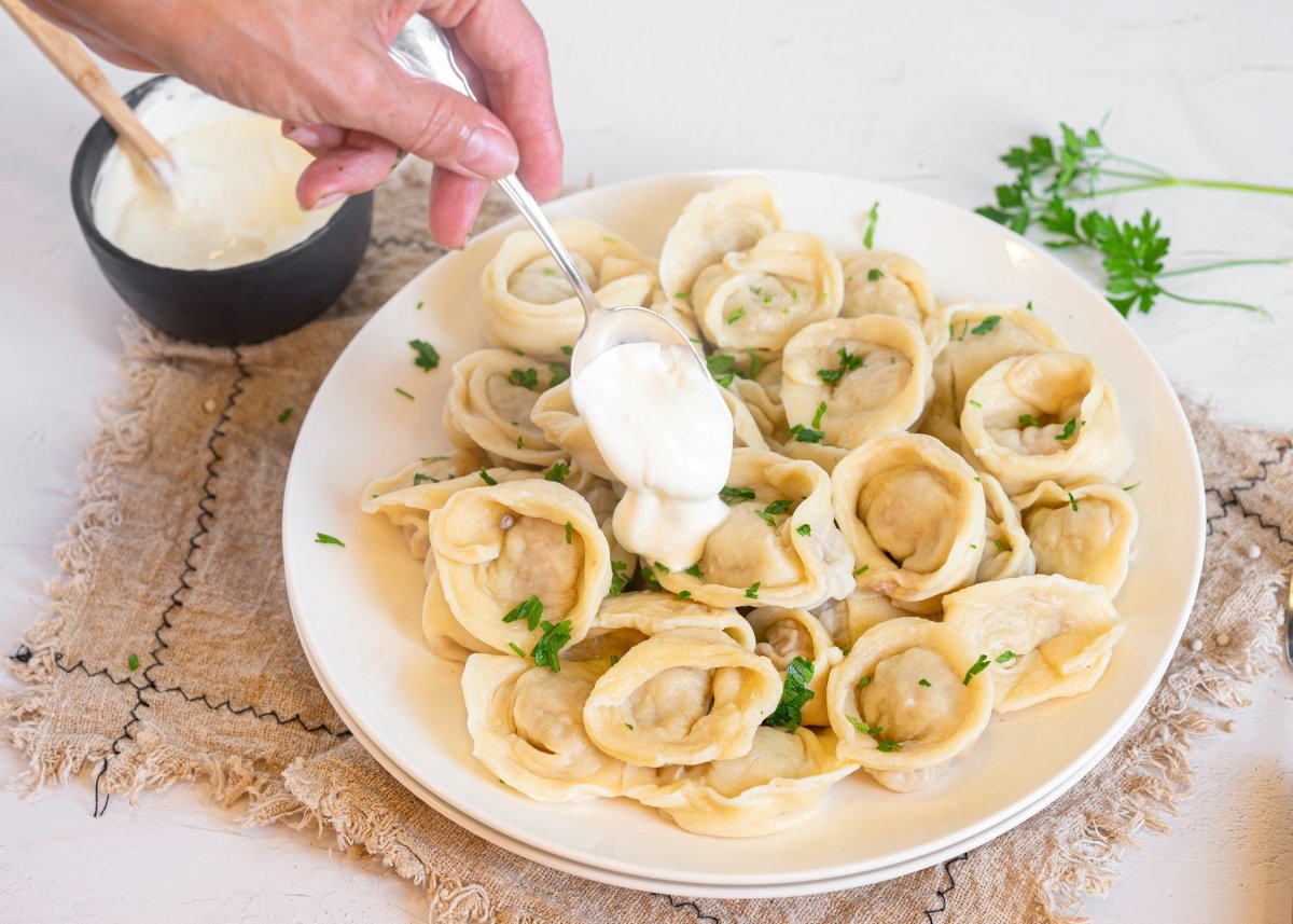 Añadiendo nata agria a los pelmeni