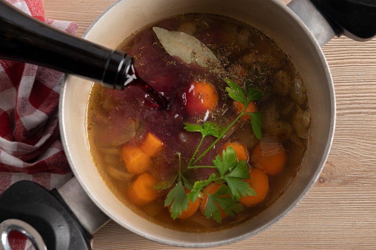 Añadiendo vino al fondo del coq au vin
