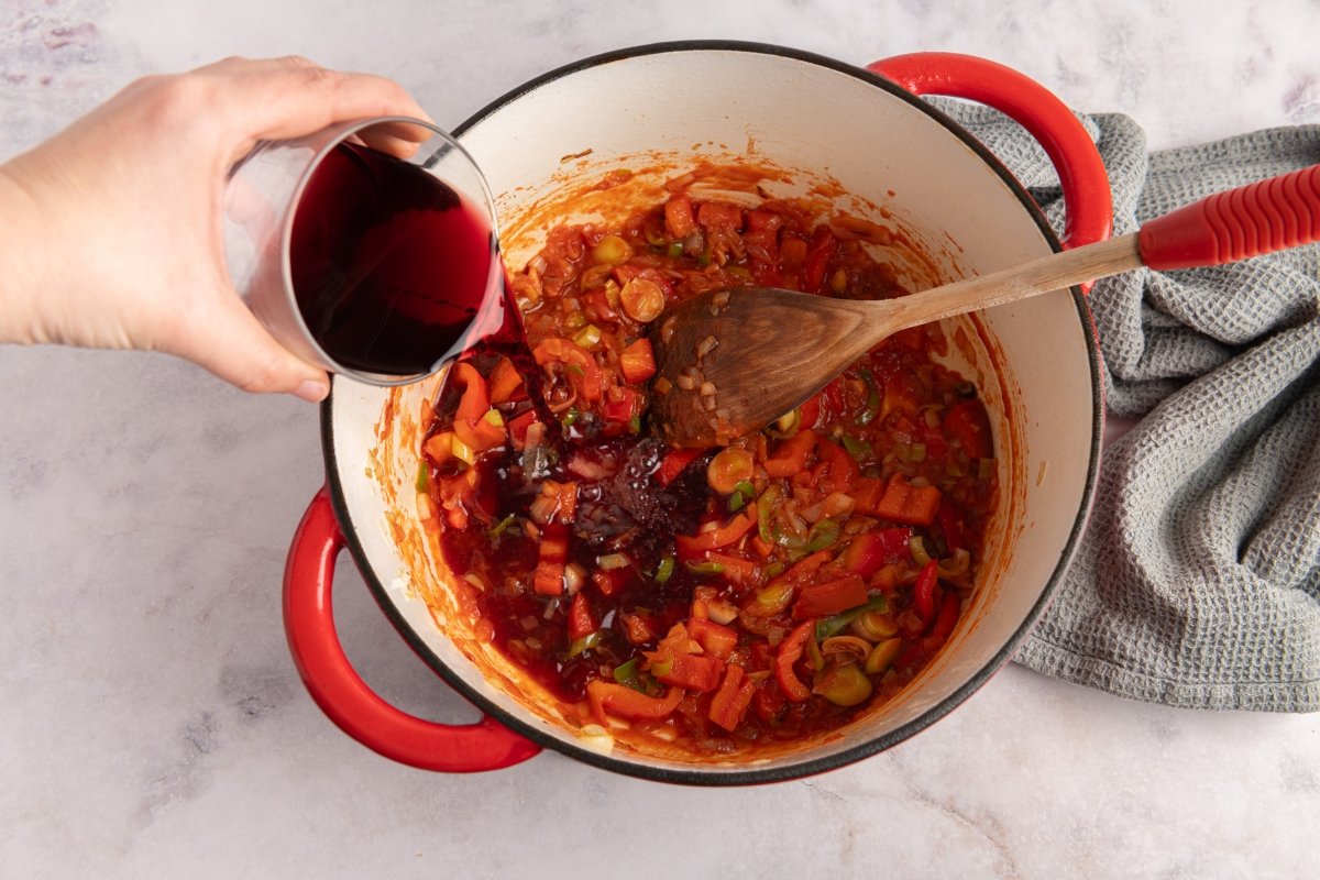 Añadiendo vino al sofrito del jarrete de ternera guisado con patatas