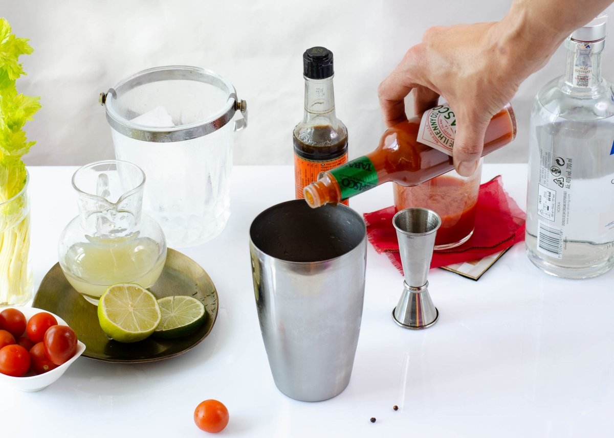 Adding tabasco to cocktail shaker to make Bloody Mary