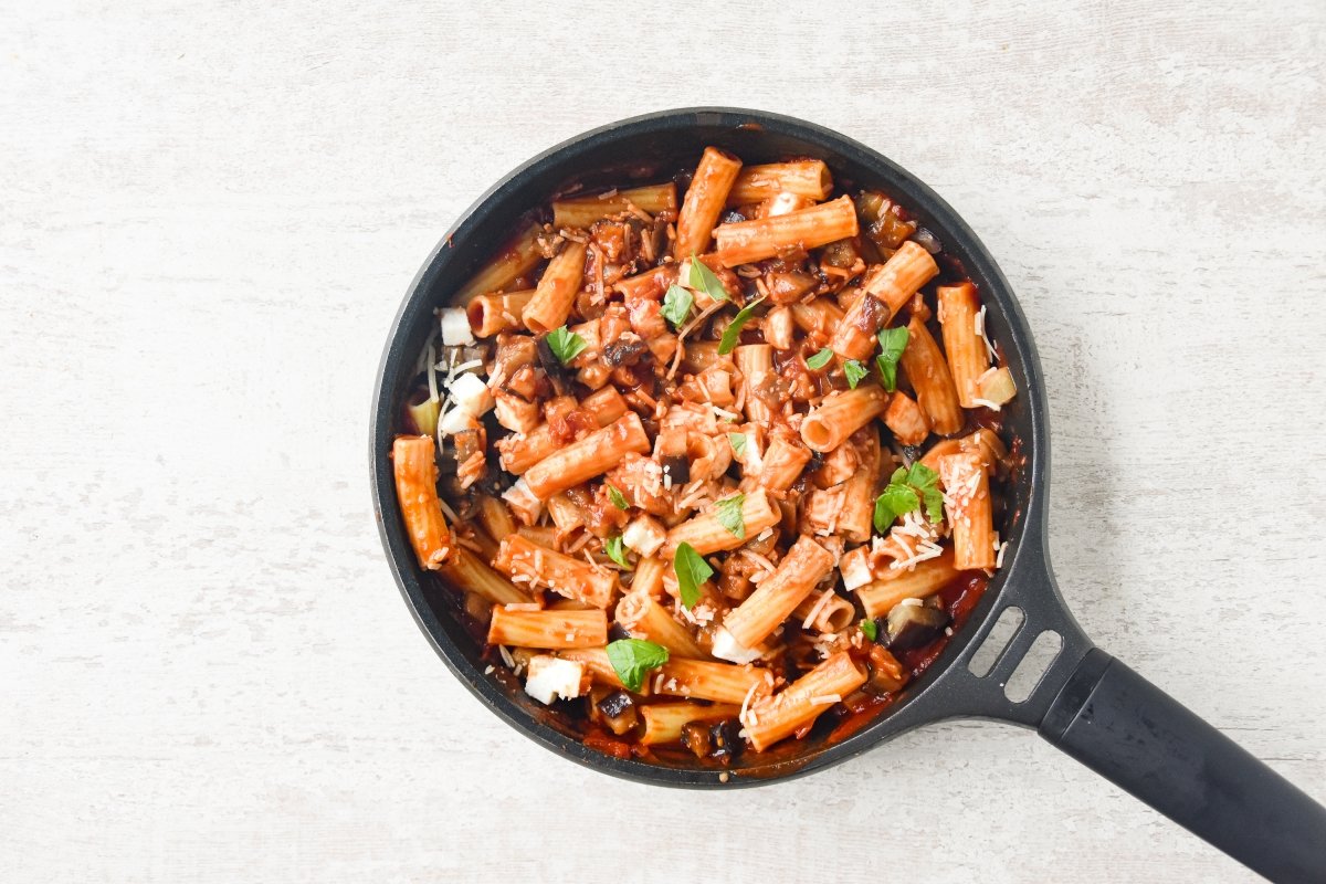 Añadimos a la pasta la berenjena y parte de los quesos