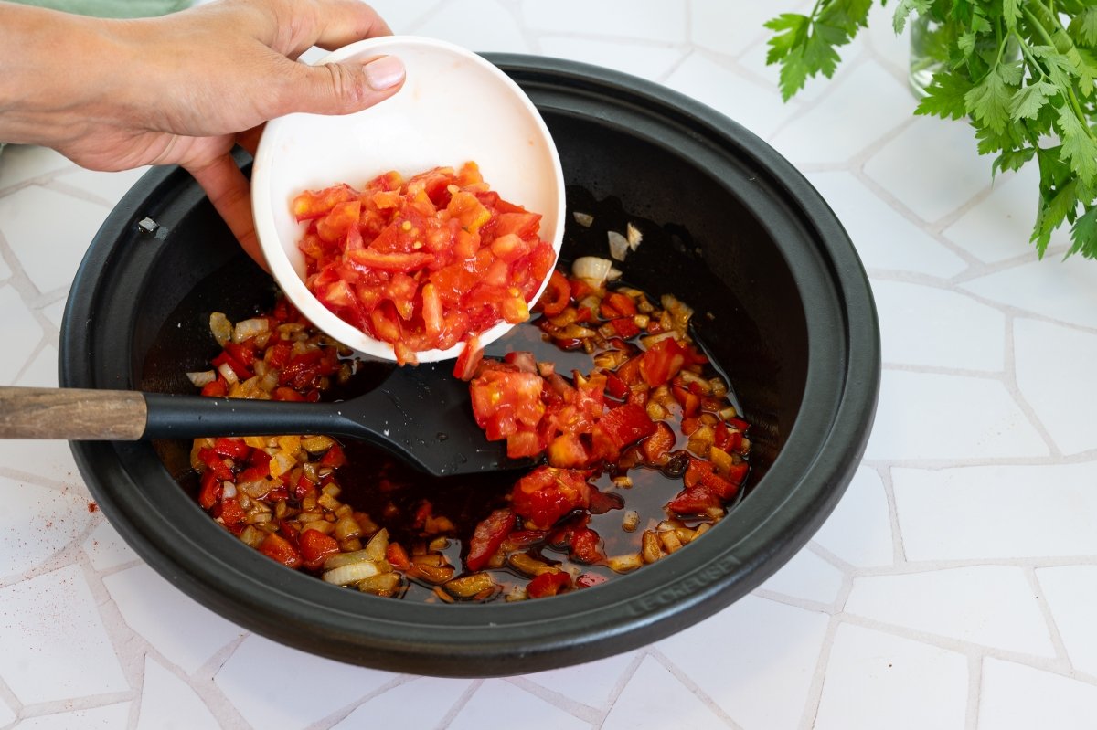 Añadimos el tomate en cubos para la base del arroz caldoso con bacalao