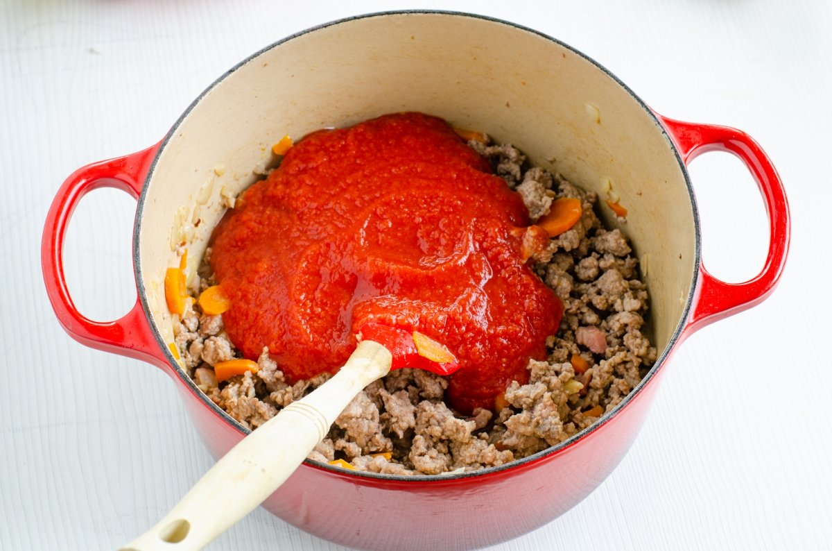 Añadimos el tomate triturado a la carne para hacer tallarines a la boloñesa