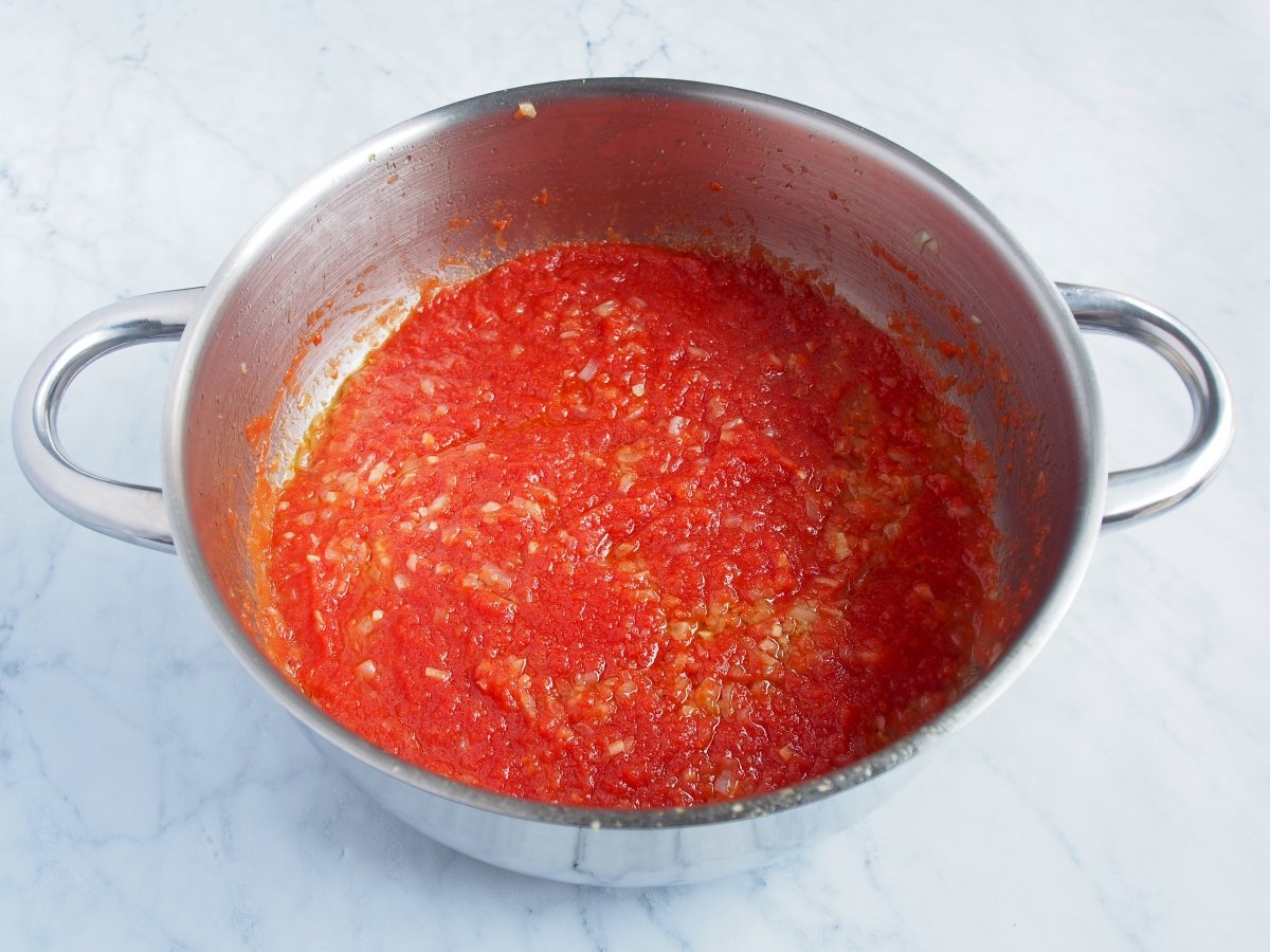 Añadimos el tomate triturado, sal y pimienta negra molida