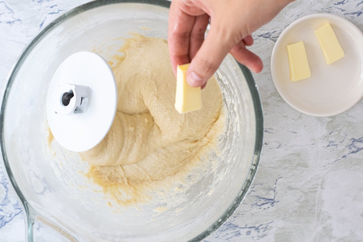 Añadimos la mantequilla a la masa de las donas con azúcar