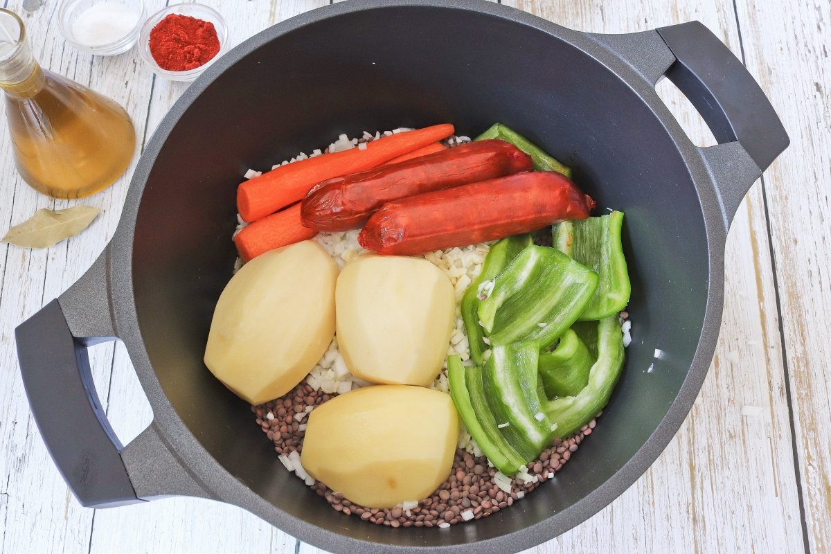 Añadir a la olla de las lentejas los chorizos, las verduras y las patatas