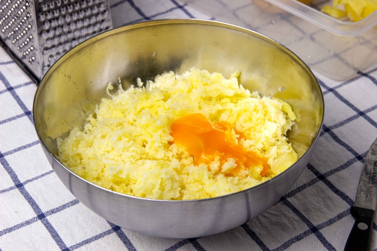 Add the egg yolk to the grated potatoes