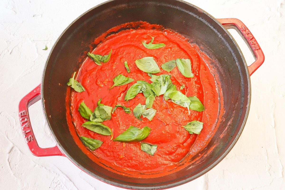 Añadir albahaca a la salsa marinara de los manicotti