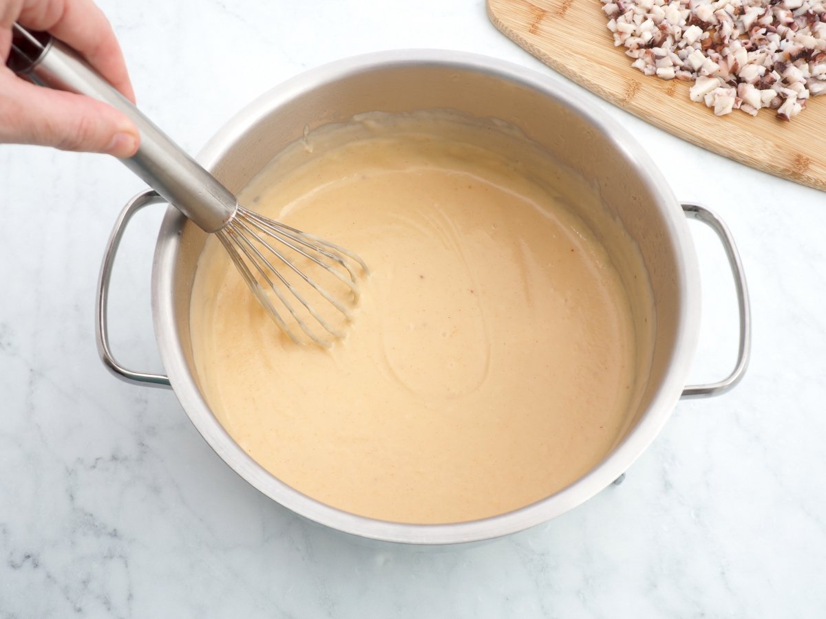 Añadir el agua de cocción del pulpo y la leche para la bechamel
