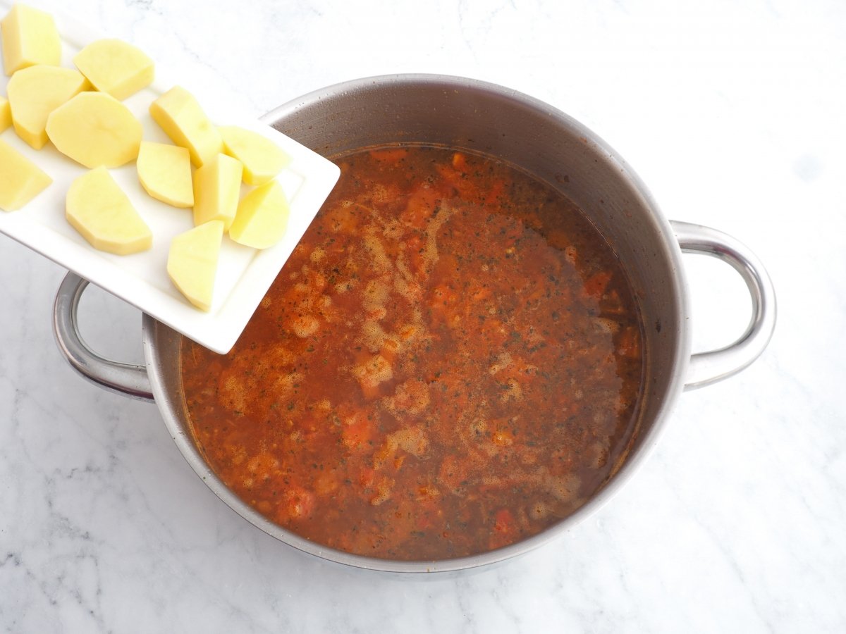 Añadir el agua y las patatas