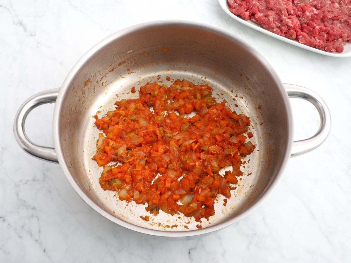 Añadir el ajo y el tomate al sofrito