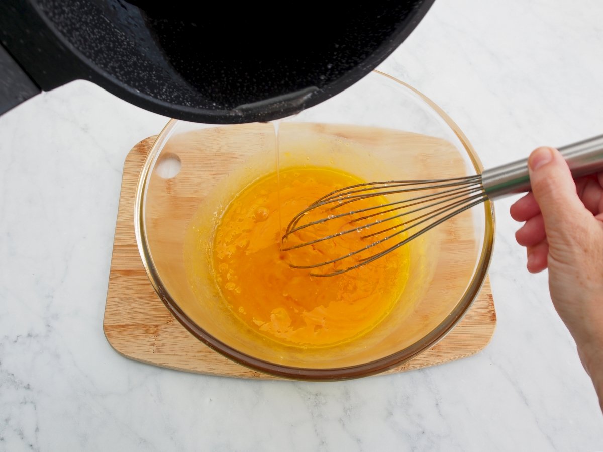 Añadir el almíbar a la crema de yema para las rosquillas de Alcalá