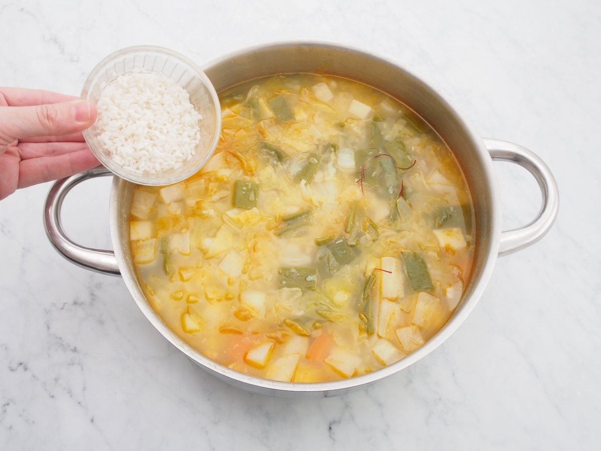 Añadir el arroz a la cazuela de la olla de la plana