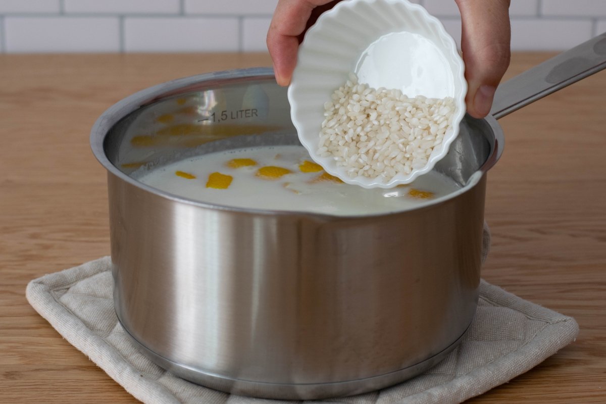 Añadir el arroz a la leche con canela y piel de limón