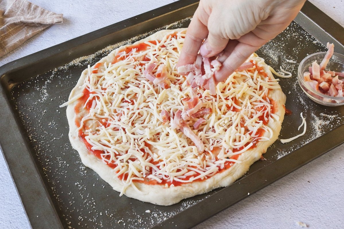 Añadir el bacon a la pizza de queso de cabra