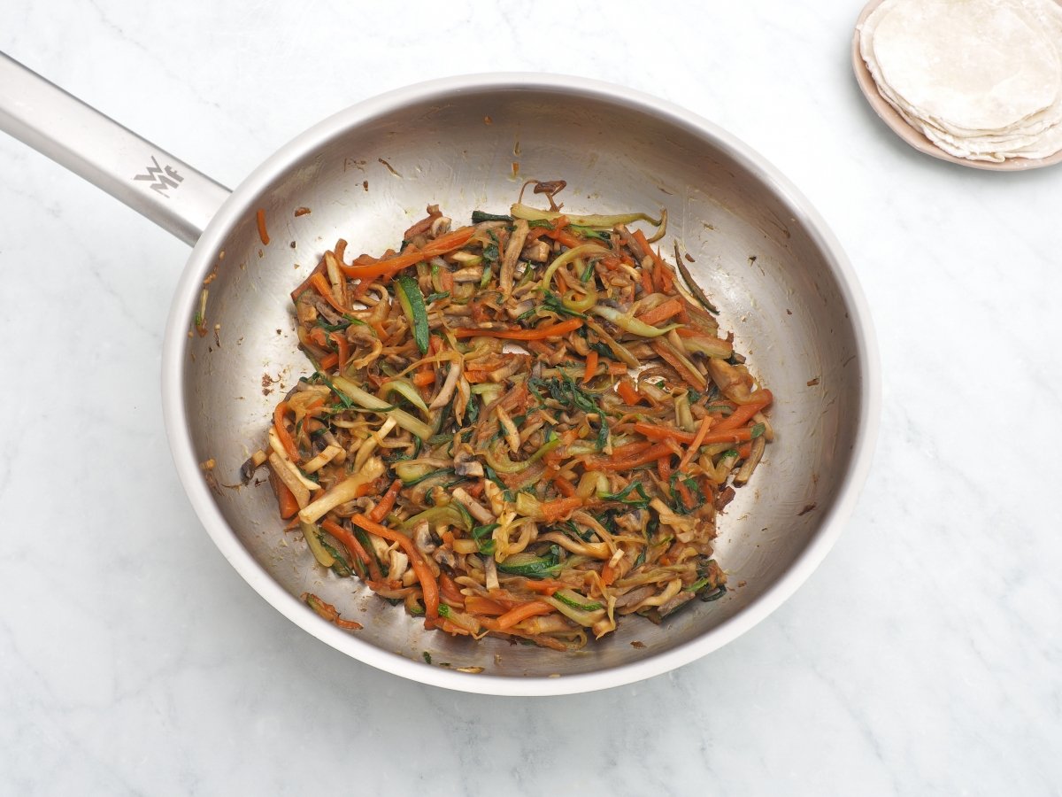 Añadir el calabacín y la col al salteado