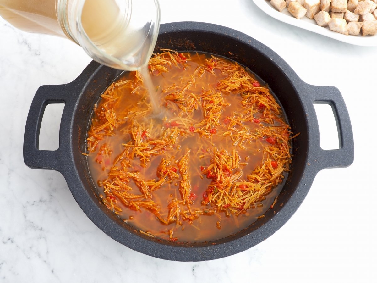 Añadir el caldo de carne para la fideuá