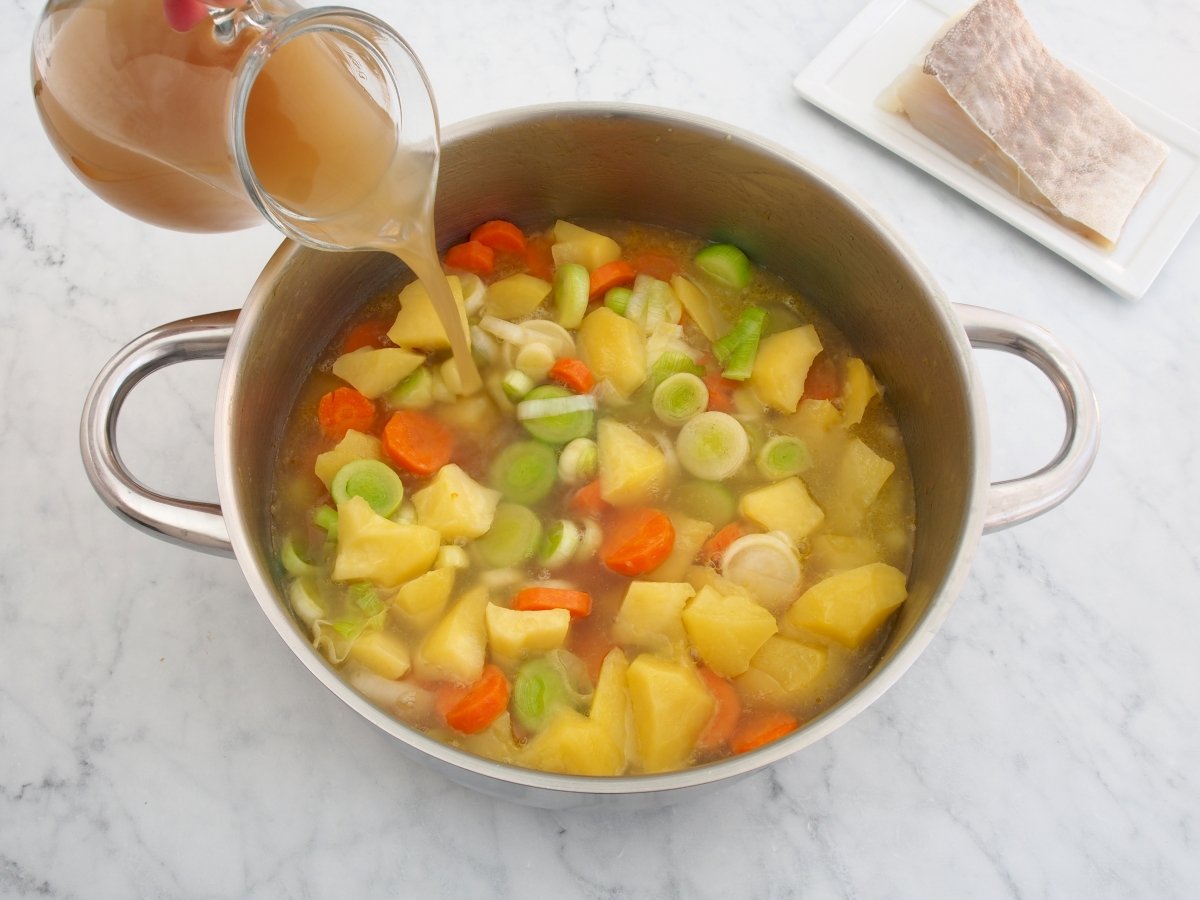 Añadir el caldo de verduras a la porrusalda con bacalao