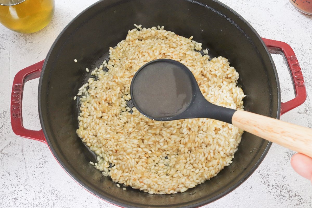 Añadir el caldo poco a poco para cocinar el risotto a la parmesana