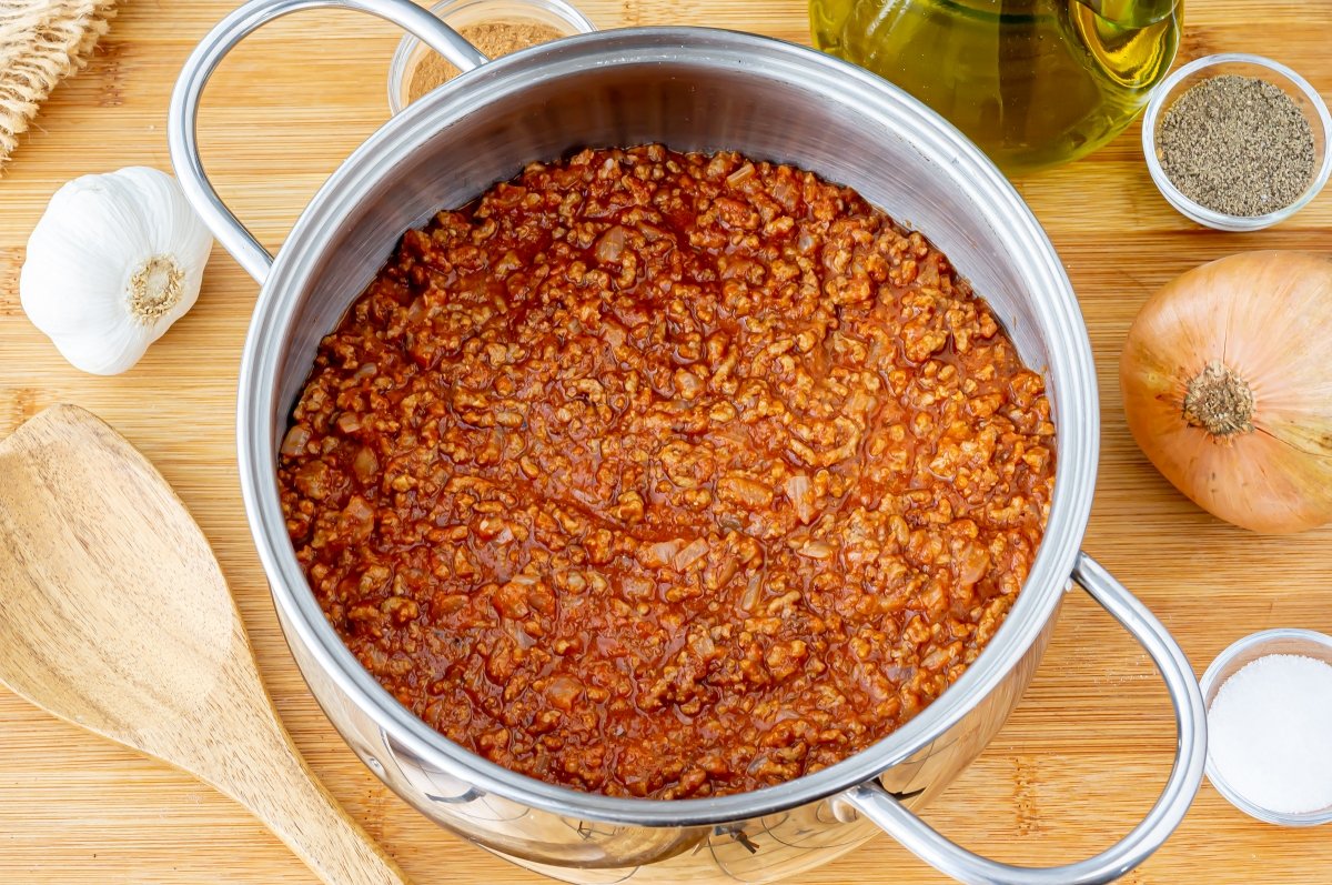 Añadir el concentrado de tomate, mitad de la canela, mitad de la nuez moscada y los clavos molidos