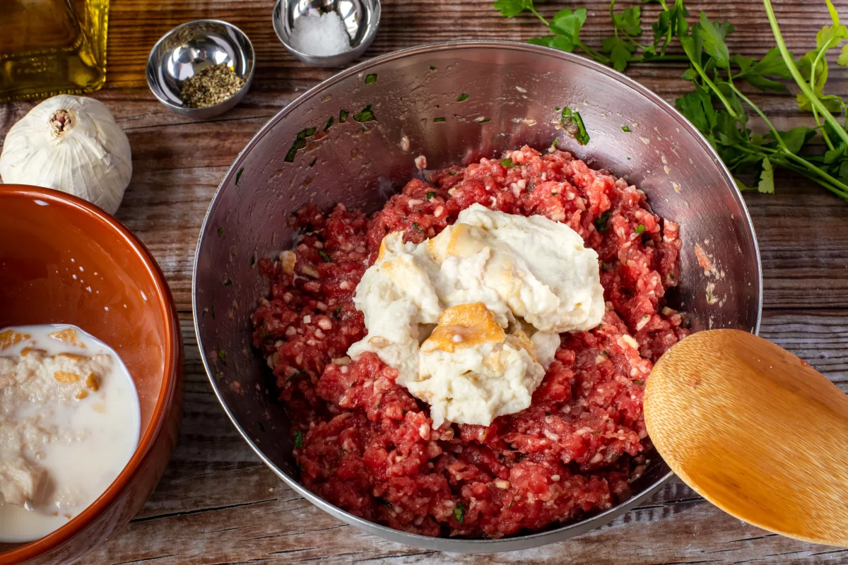 Añadir el pan remojado en leche y escurrido a la carne para las albóndigas de carne en salsa