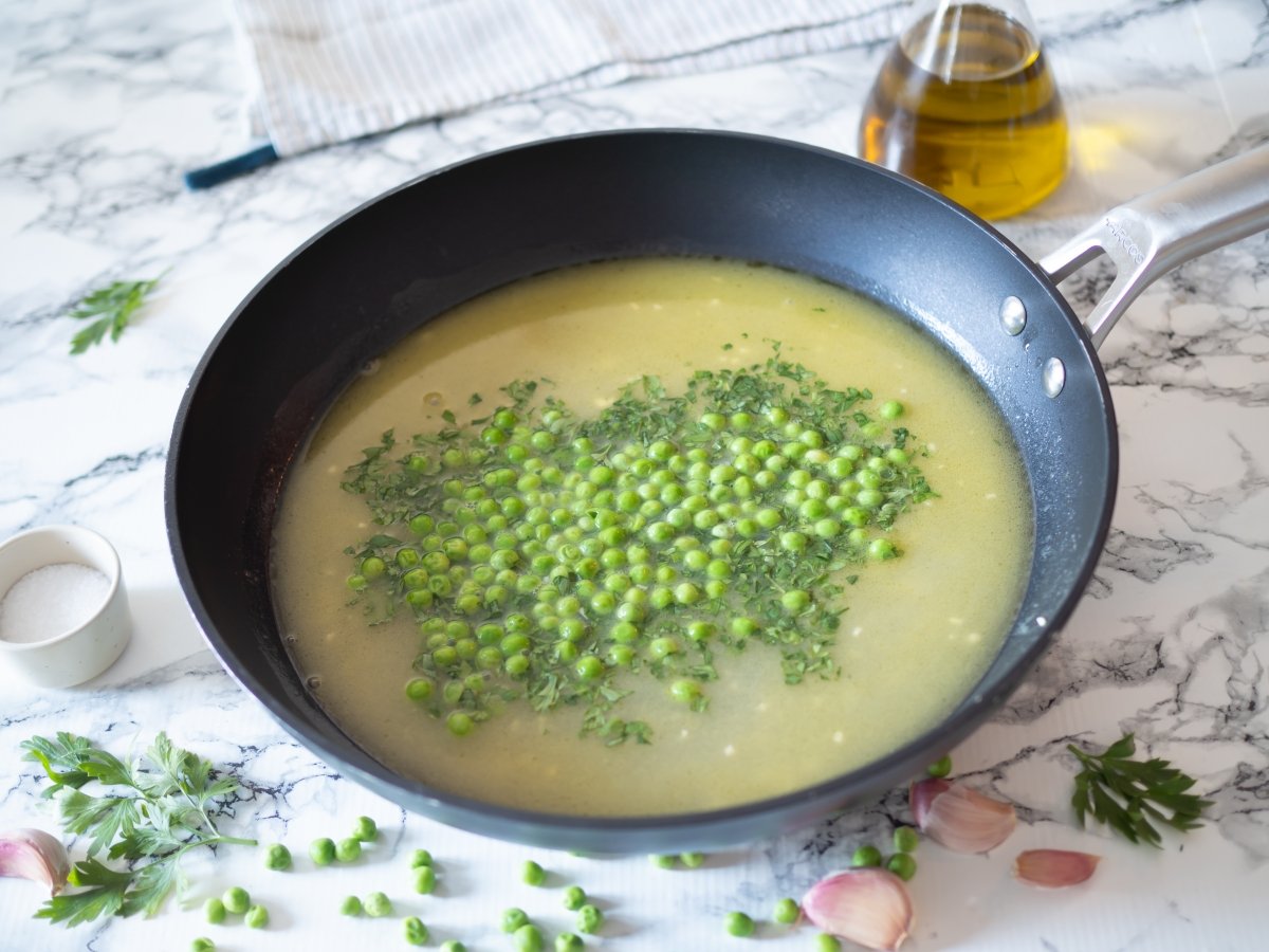 Añadir el perejil y los guisantes para la lubina en salsa verde